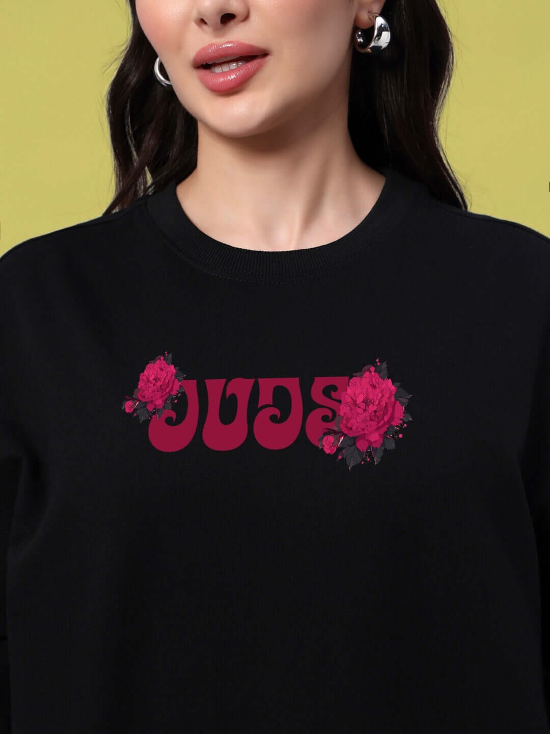 Woman wearing an oversized black t-shirt with pink skull rose design, showcasing trendy summer fashion.