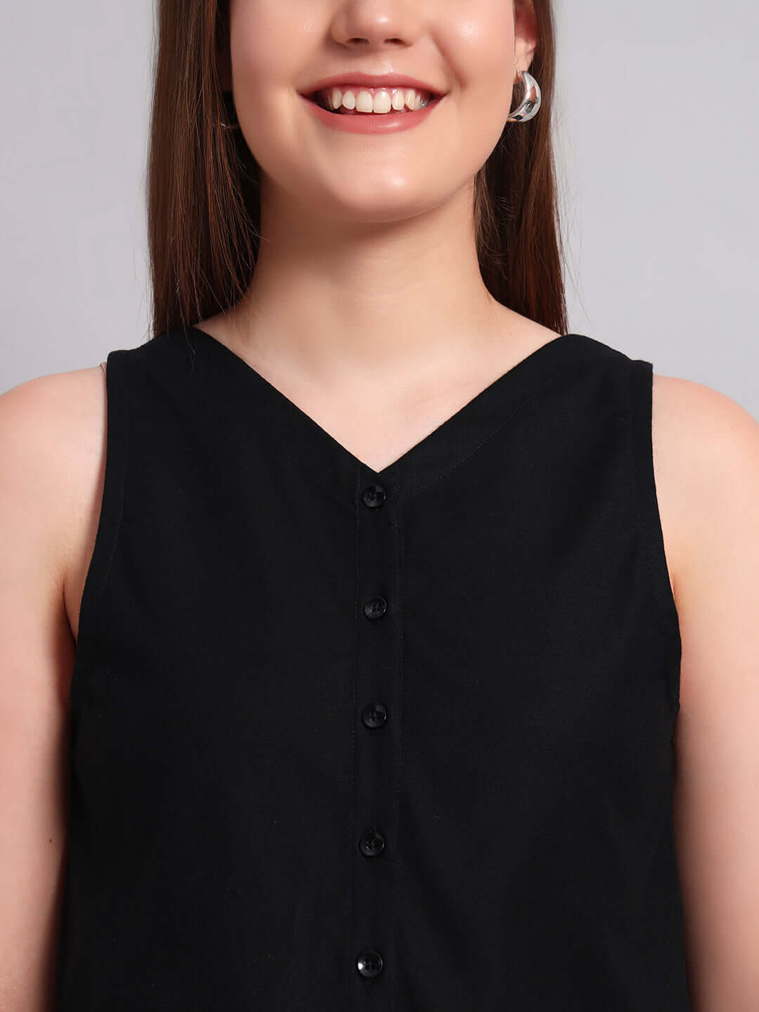 Close-up of a woman wearing a WOMEN'S CHIC CROP-TOP V NECK BLACK, showcasing button details and modern style.