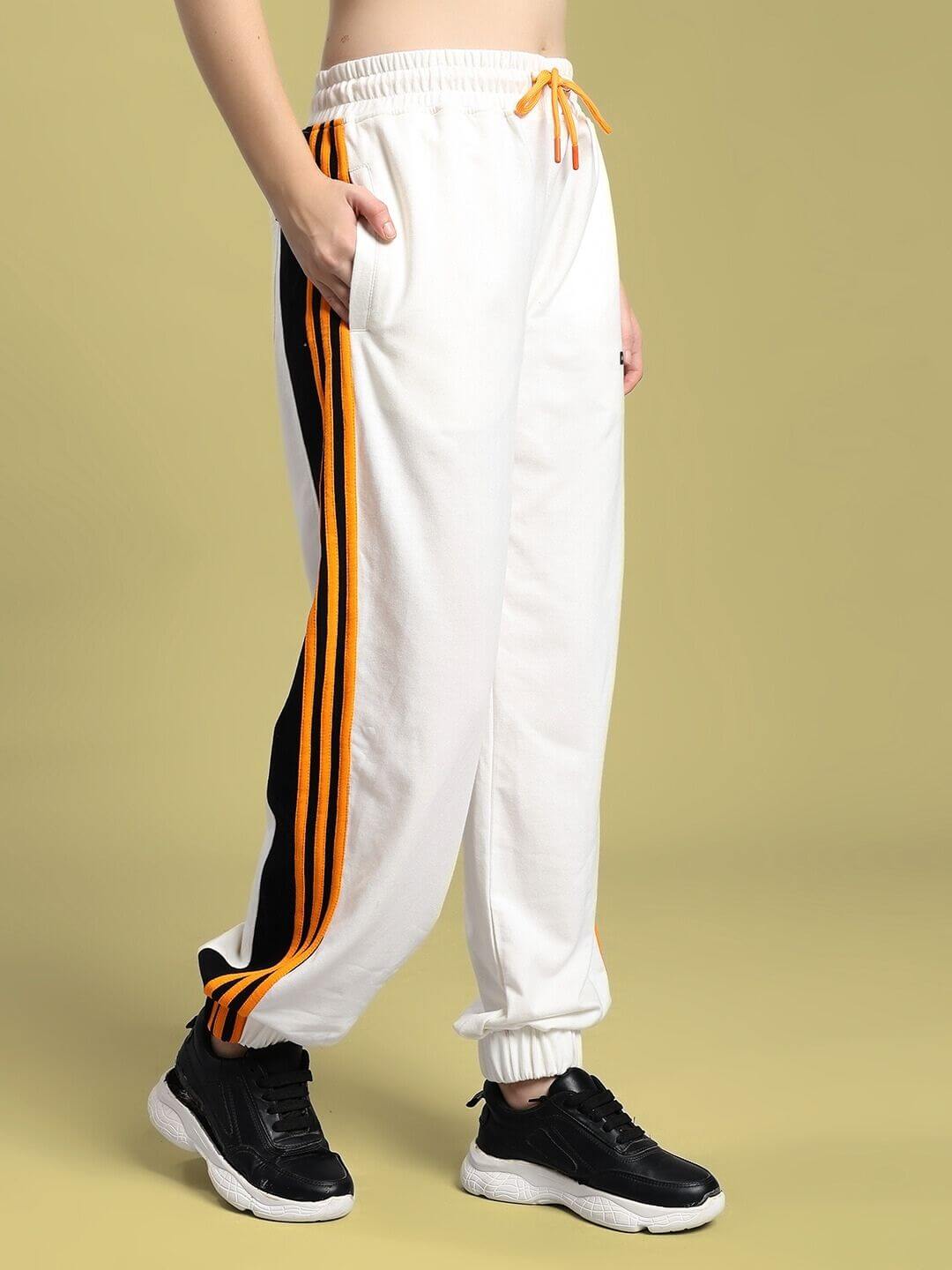 Woman wearing WOMEN'S COMFORT FLEX STRIPE JOGGER OFF-WHITE with vertical stripes and sneakers.