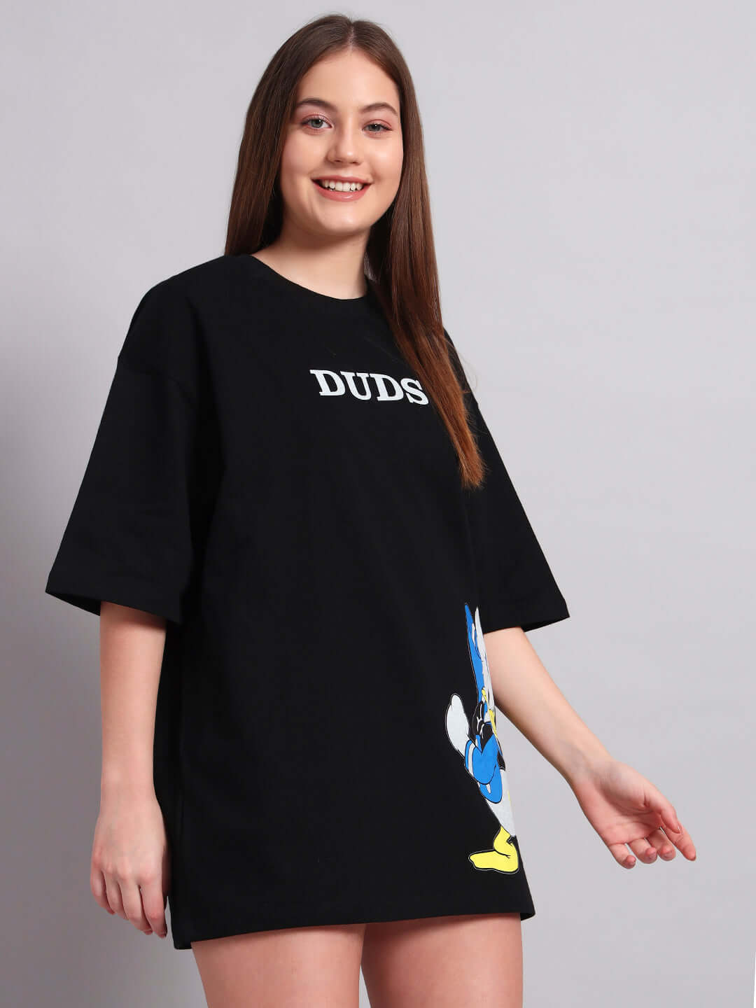 Woman wearing black oversized T-shirt with Donald Duck print, made of premium cotton fabric, 240 GSM, bio-washed, made in India.