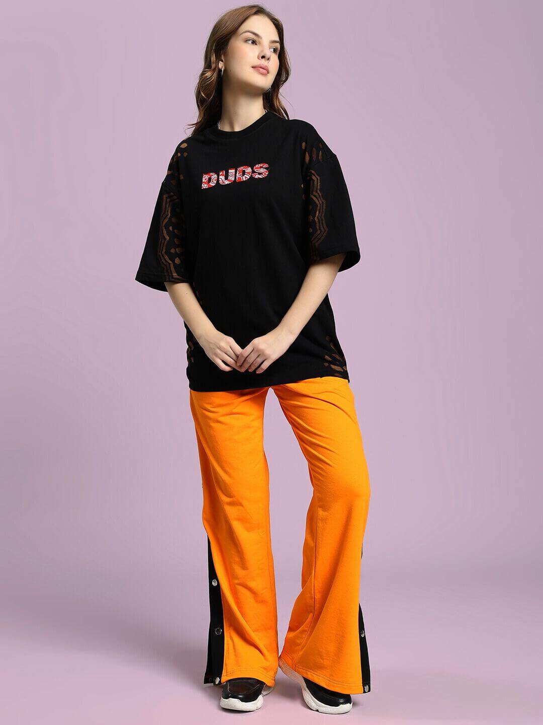 Model wearing WOMEN'S EMBER BOLT SIDE JOGGER ORANGE with side stripe detailing, showcasing vibrant casual wear on soft, lightweight fabric.