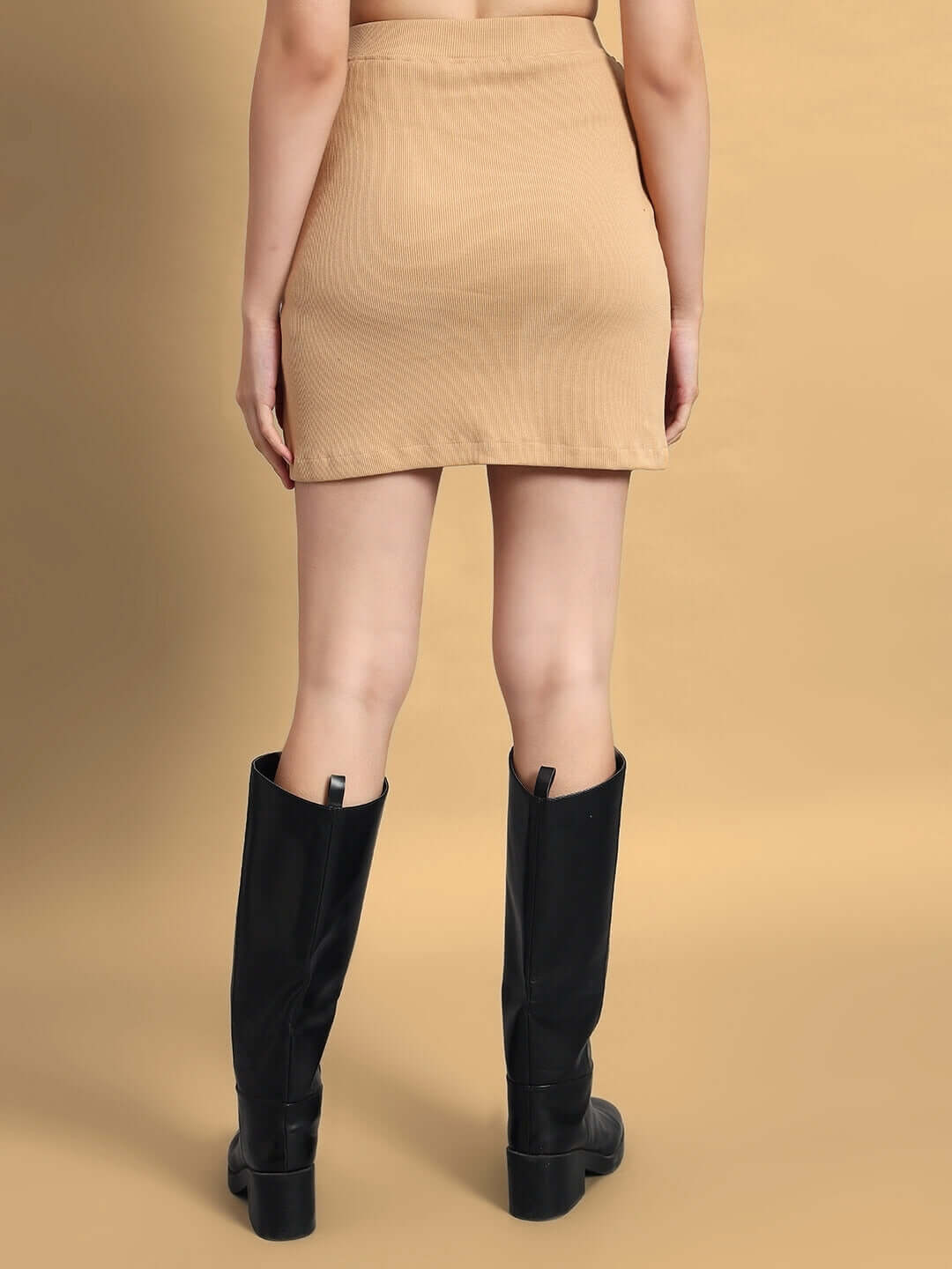 Back view of Women's Emma Designer Skirt in beige, paired with black boots, highlighting its stylish look and elegant design.