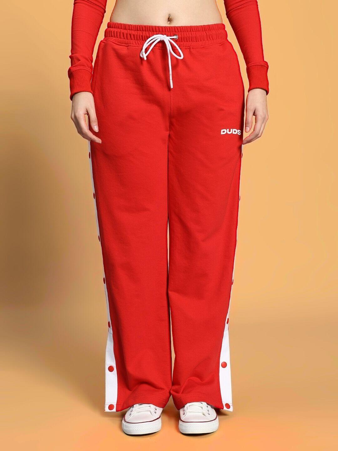 Model wearing WOMEN'S EZEL CO-ORD SET RED-WHITE, showcasing bold sporty style with red pants and white accents.