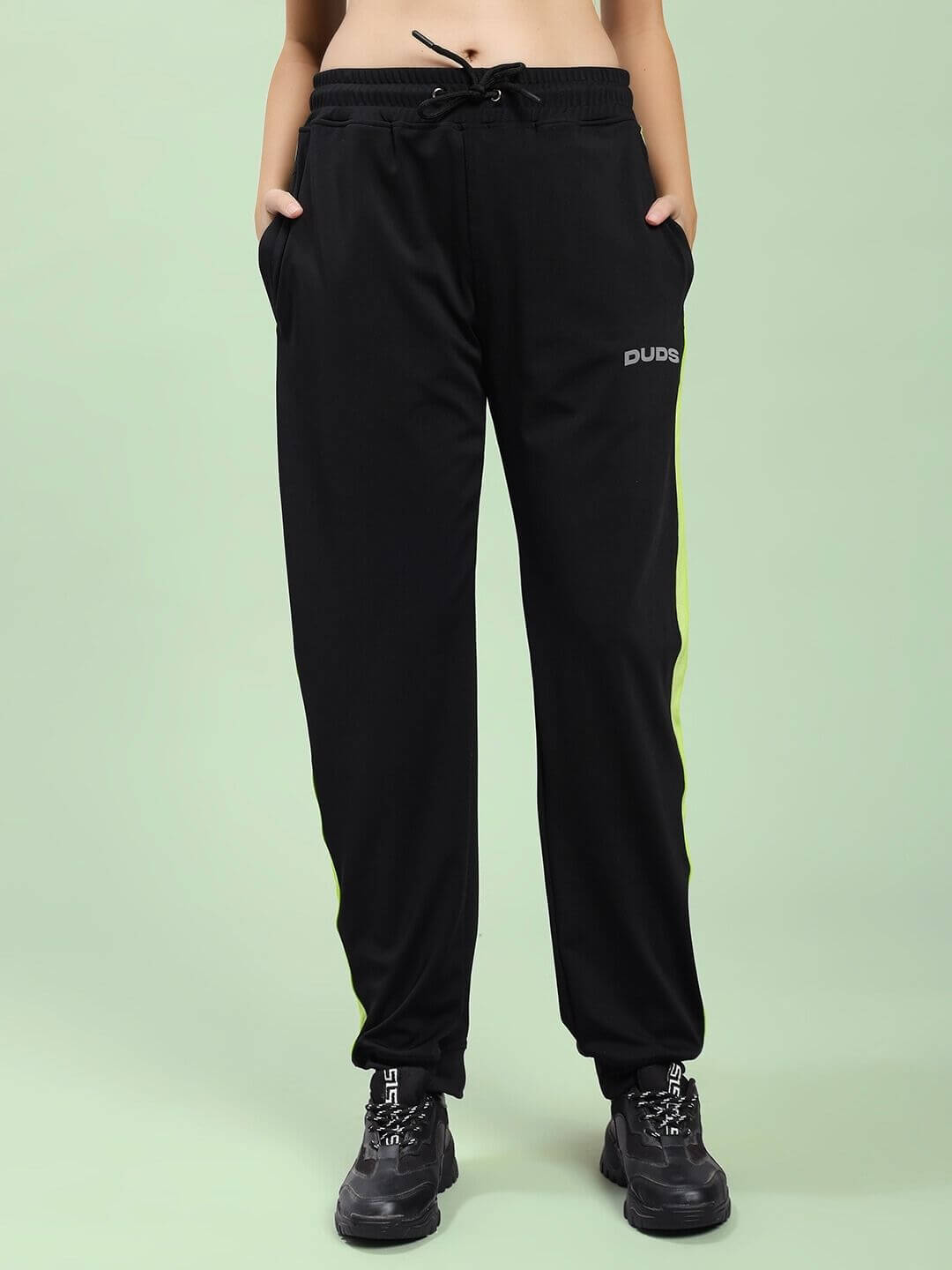 Model wearing WOMEN HIGH PERFORMANCE CO-ORD SET BLACK joggers, showcasing athletic style.