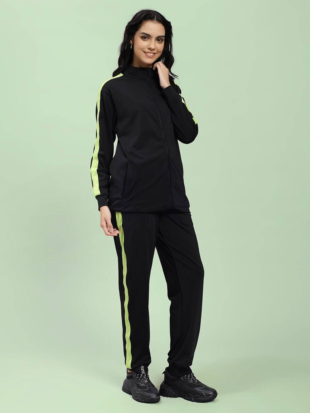 Woman wearing WOMEN HIGH PERFORMANCE CO-ORD SET BLACK, featuring zip-up hoodie and tapered joggers, perfect for athleisure and workouts.