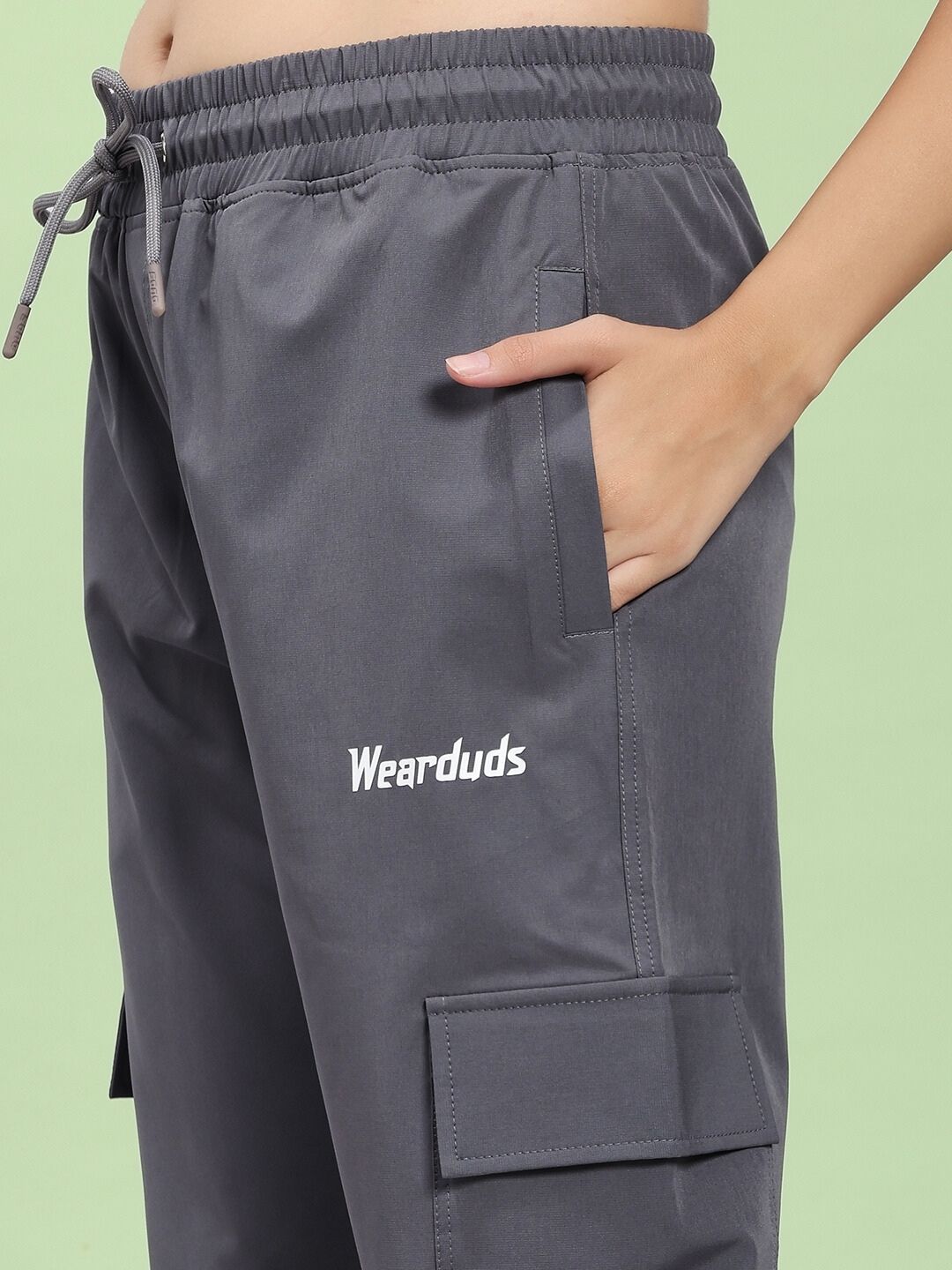 Close-up of WOMEN'S JIMMY RELAXED FIT MULTI POCKET JOGGER DARK GREY with hand in pocket, showing utility and street style fashion.