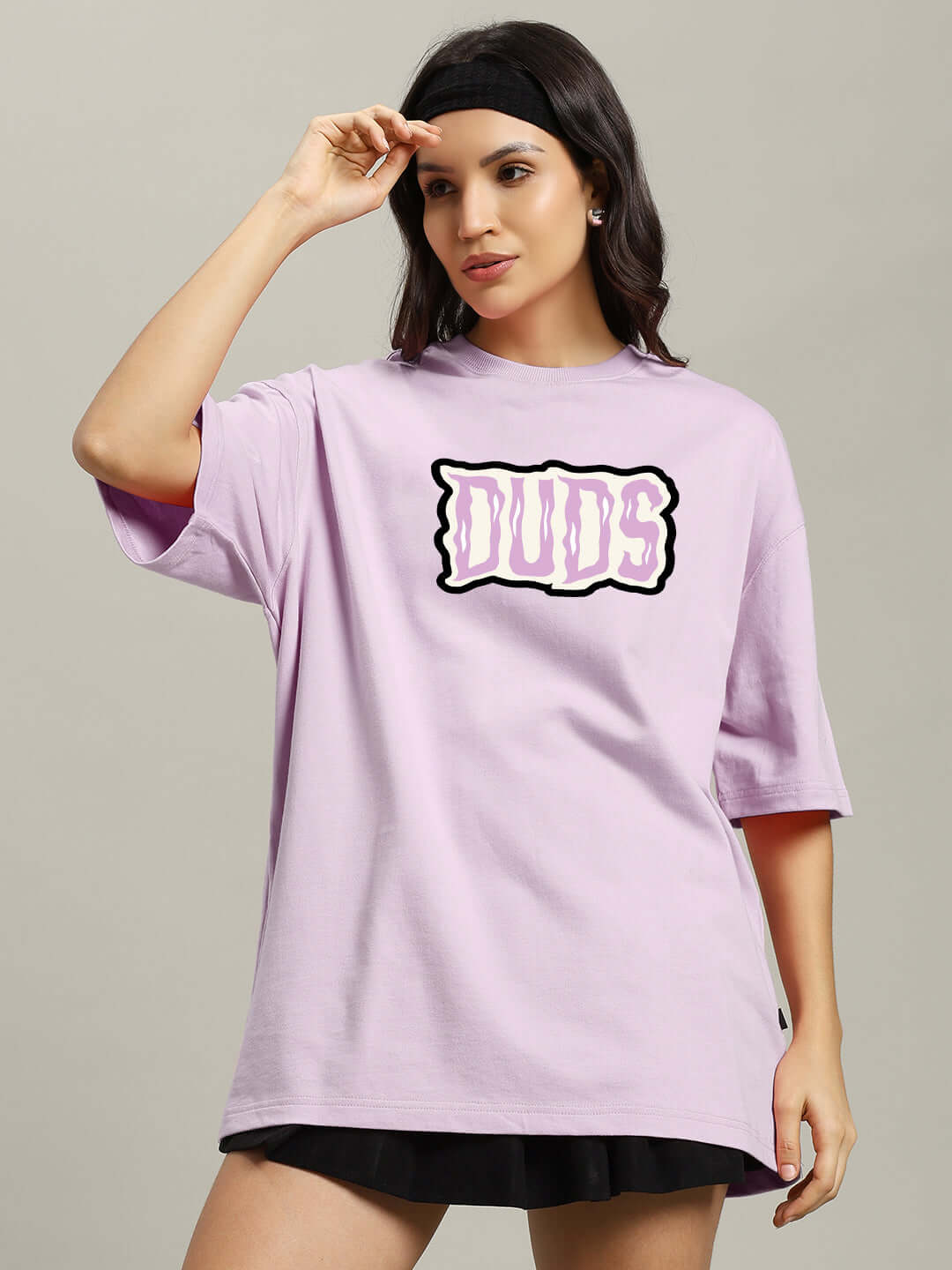 Woman wearing a lavender oversized t-shirt with 'DUDS' graphic, designed with premium cotton French terry and elastane, perfect for a spooky look.