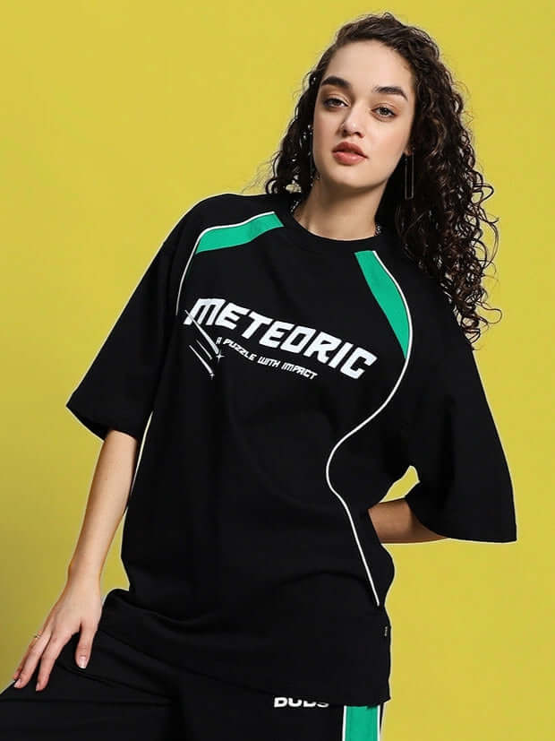 Woman wearing black oversized Meteoric T-shirt made of premium cotton with green accents, designed by Color By Colours.