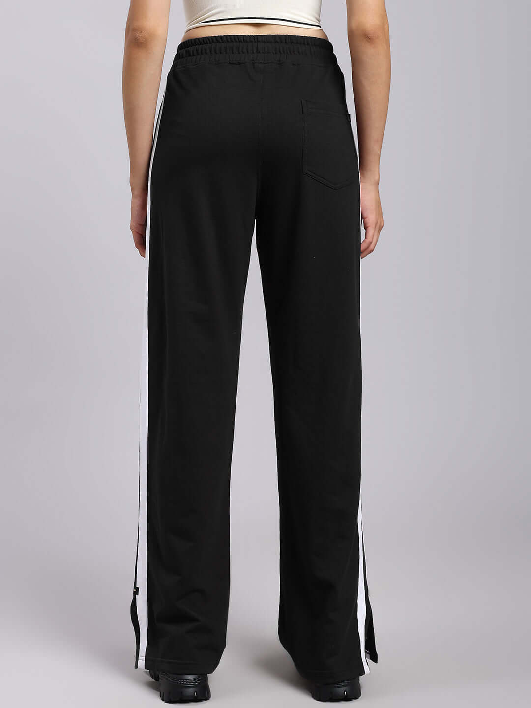 Back view of WOMENS MOSCOW RELAXED FIT JOGGERS BLACK with white side stripe and elastic waistband, showcasing a modern and comfortable design.