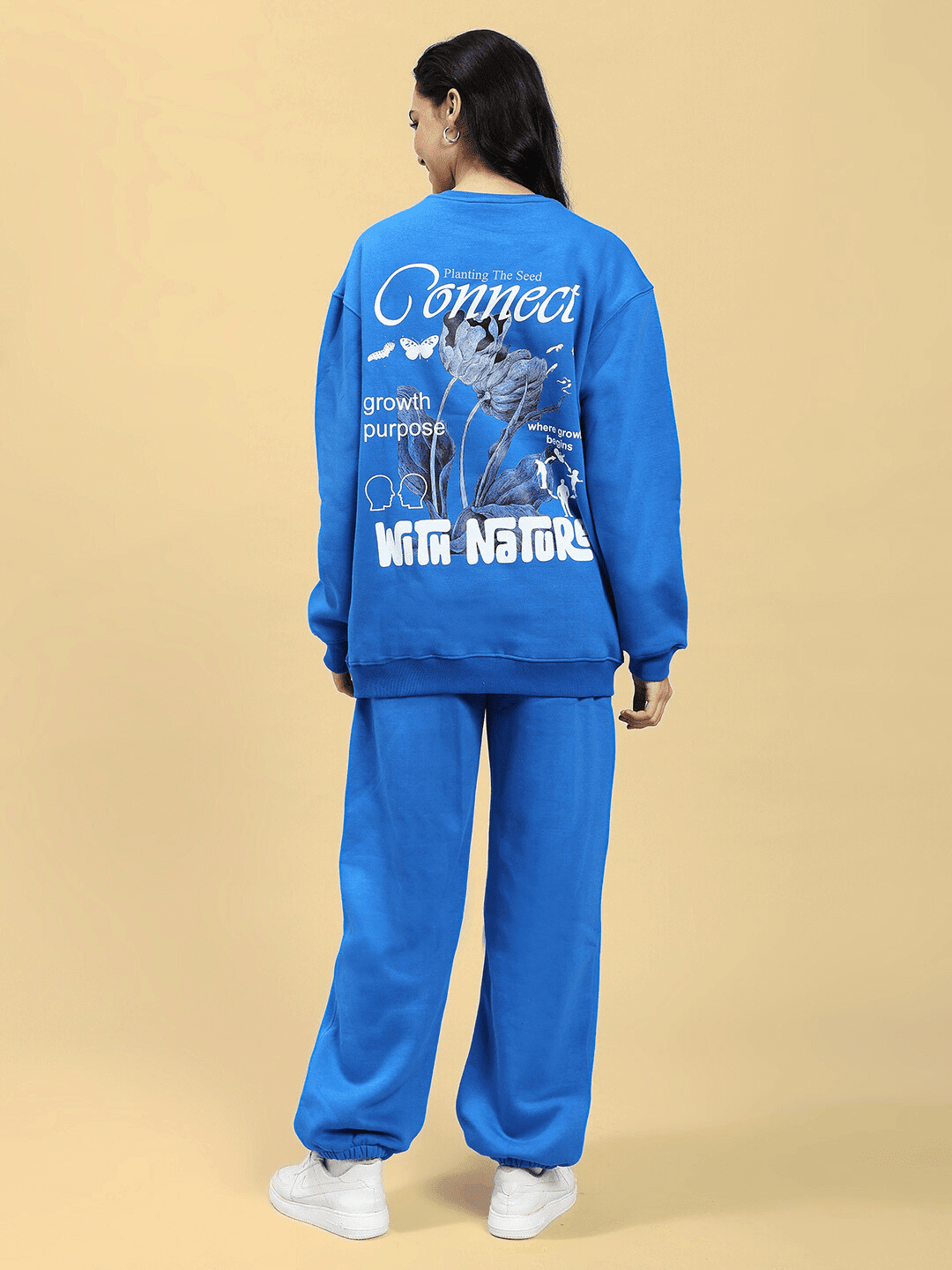 Back view of model wearing WOMEN NATURE LINK FLEECE CO-ORD SET ROYAL BLUE featuring sweatshirt and joggers, highlighting design details.