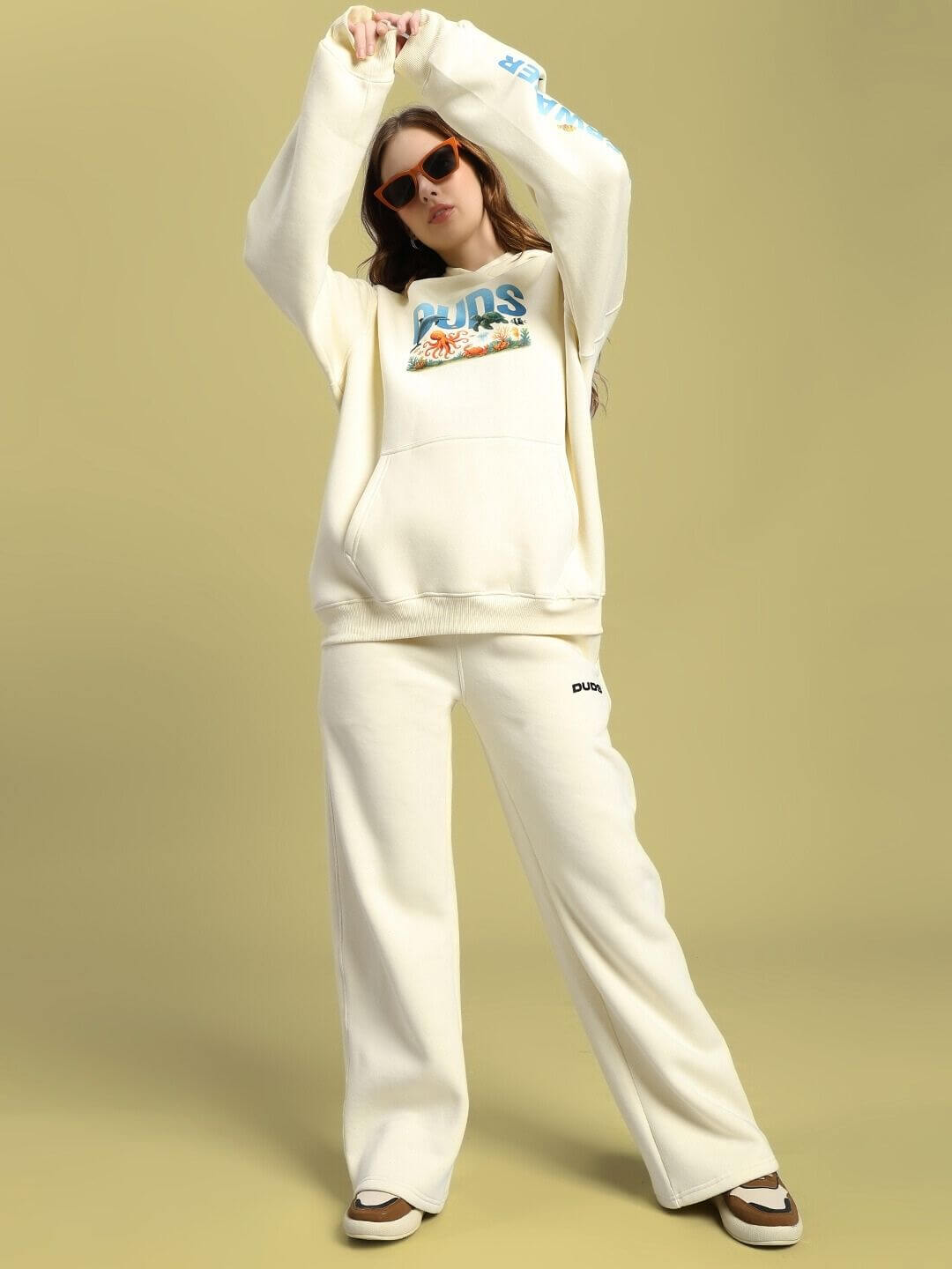 Model wearing WOMEN OCEAN BUDDIES OVERSIZED FLEECE HOODIE OFF-WHITE, showcasing its relaxed fit and cozy design.