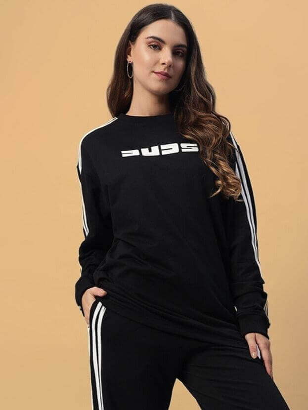 Model wearing oversized black sweatshirt with stripes, featuring premium cotton French terry, bio-washed for comfort and style.