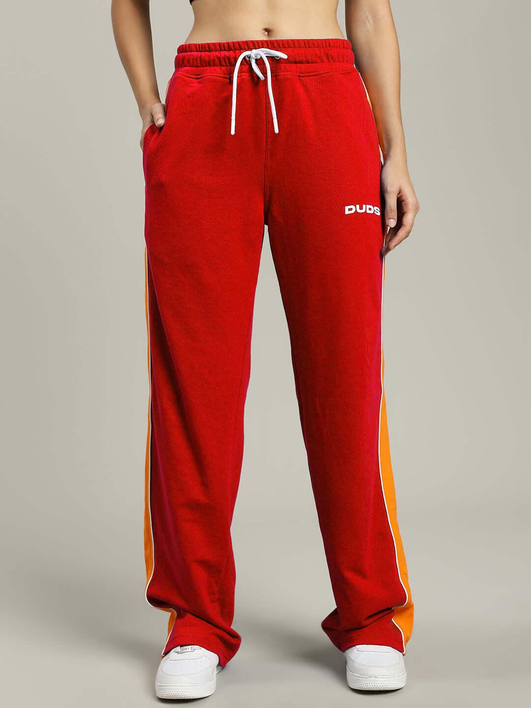 Women's red Sanford stripe joggers by DUDS, front view, featuring an orange side stripe, with customizable size options available.