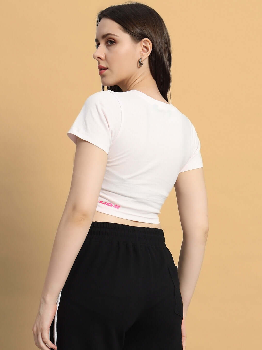Back view of woman wearing WOMEN SCORPIO CROP-TOP BABY PINK, showcasing the soft and breathable material, ideal for casual style.