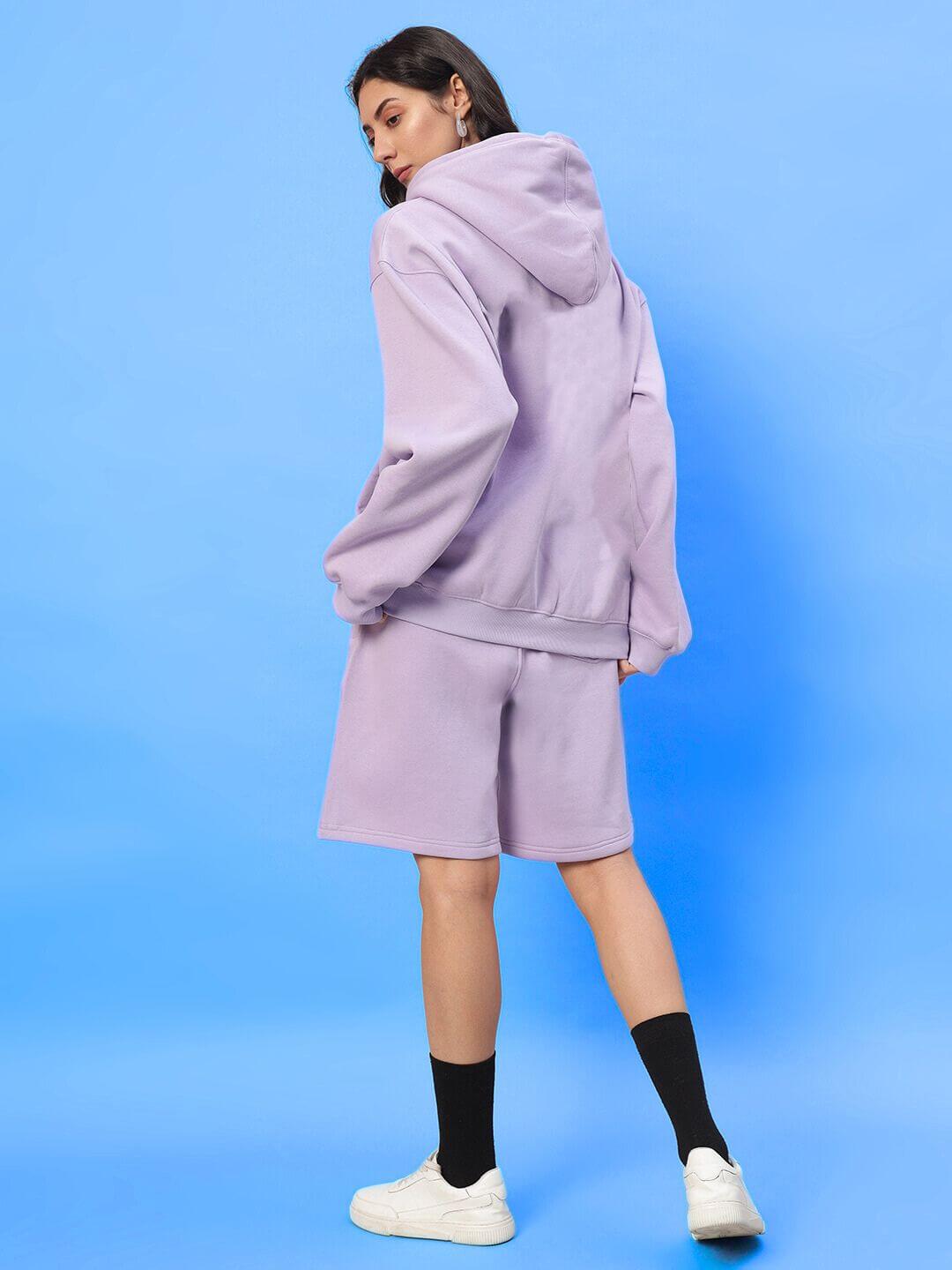 WOMENS SILENT HUG PRINTED FLEECE CO-ORD LILAC modeled against a blue background, showcasing lilac hoodie and shorts with cozy style.