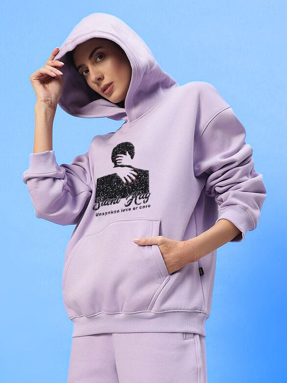 Woman wearing WOMENS SILENT HUG PRINTED FLEECE HOODIE LILAC with artistic print, showcasing modern style and comfort.