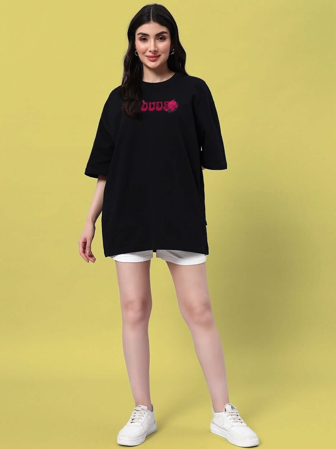 Woman wearing a black oversized t-shirt with skull and rose design, stylish summer outfit