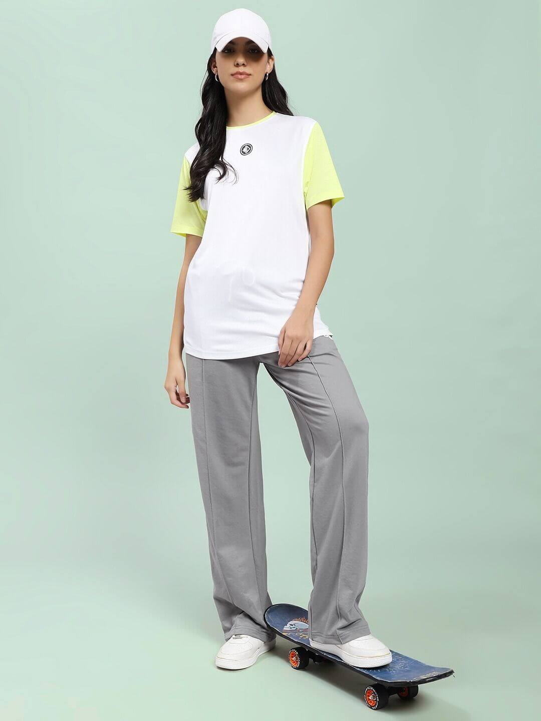 Woman wearing WOMEN SPIRAL RELAXED-FIT JOGGERS GREY standing on skateboard, showcasing casual style and comfort.