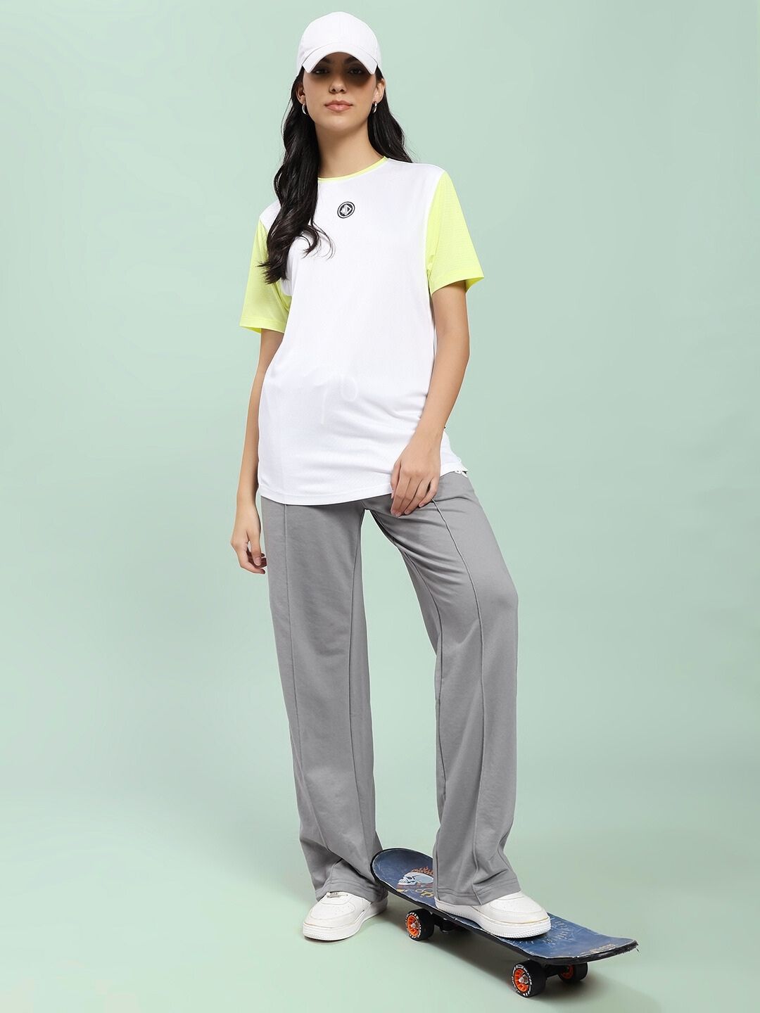 Woman wearing WOMEN'S SPIRAL RELAXED-FIT JOGGERS GREY standing on skateboard with casual outfit.