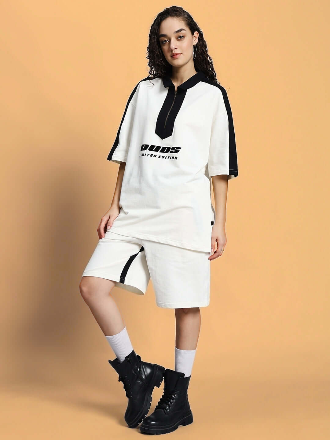 Model wearing WOMEN SPLINTER SUMMER CO-ORD SET OFF WHITE with black boots on a beige background.