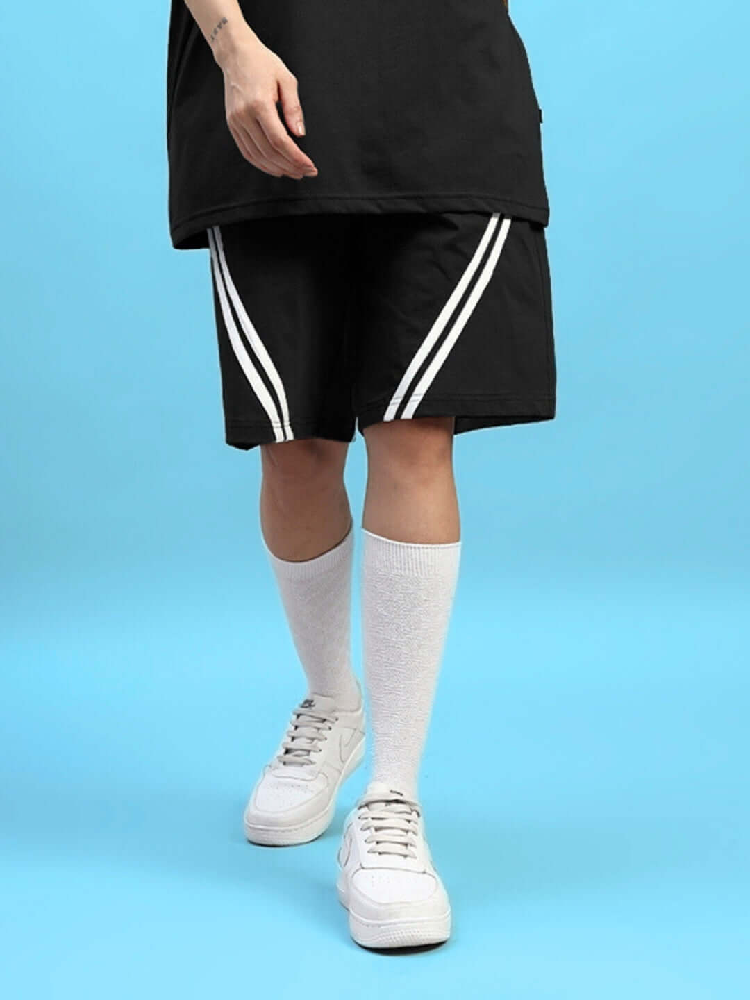 Women's black star jumper shorts, regular fit, featuring white stripe design, paired with white knee-high socks and sneakers.