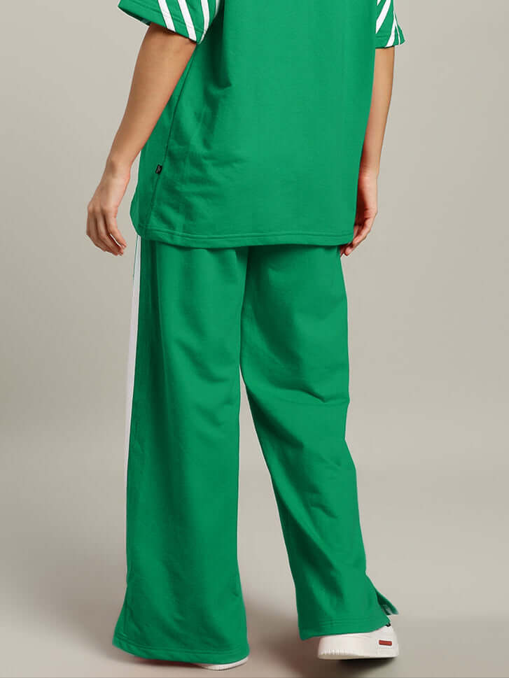 Woman wearing green United Stripe Joggers by DUDS, displaying casual style with customizable fit option.
