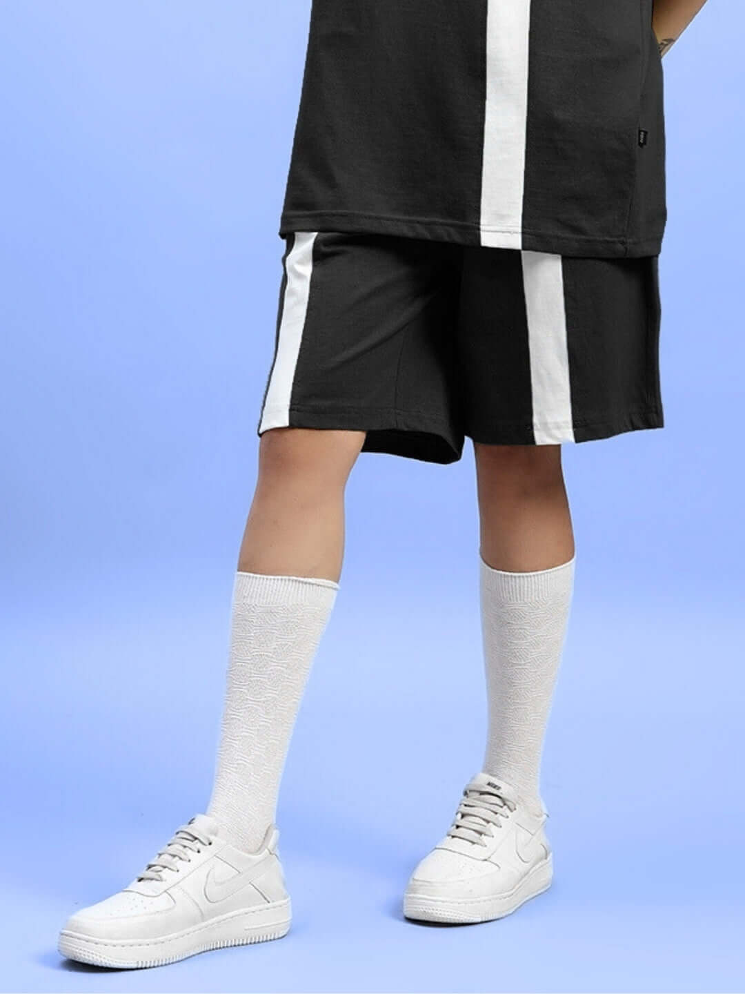Women's black wideline regular fit shorts with white side stripes, customizable size option available, paired with white sneakers.