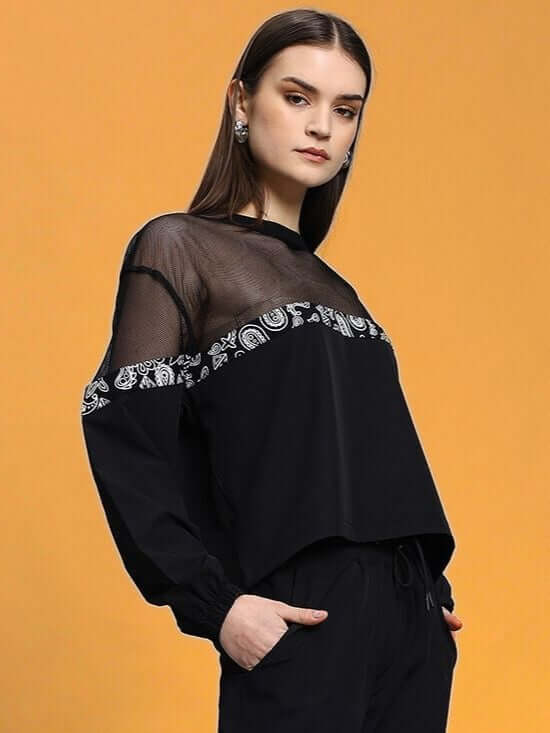 Woman wearing WOMEN'S YESMIN RELAXED FIT TOP BLACK with elegant design, showcasing the top's comfortable and stylish appeal.