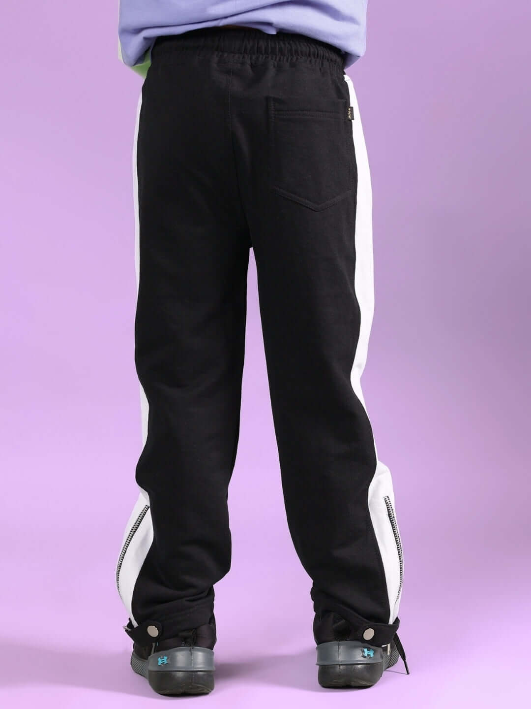 Back view of black wonder jogger pants for boys and girls with white side stripes, showcasing comfortable fit and stylish design.
