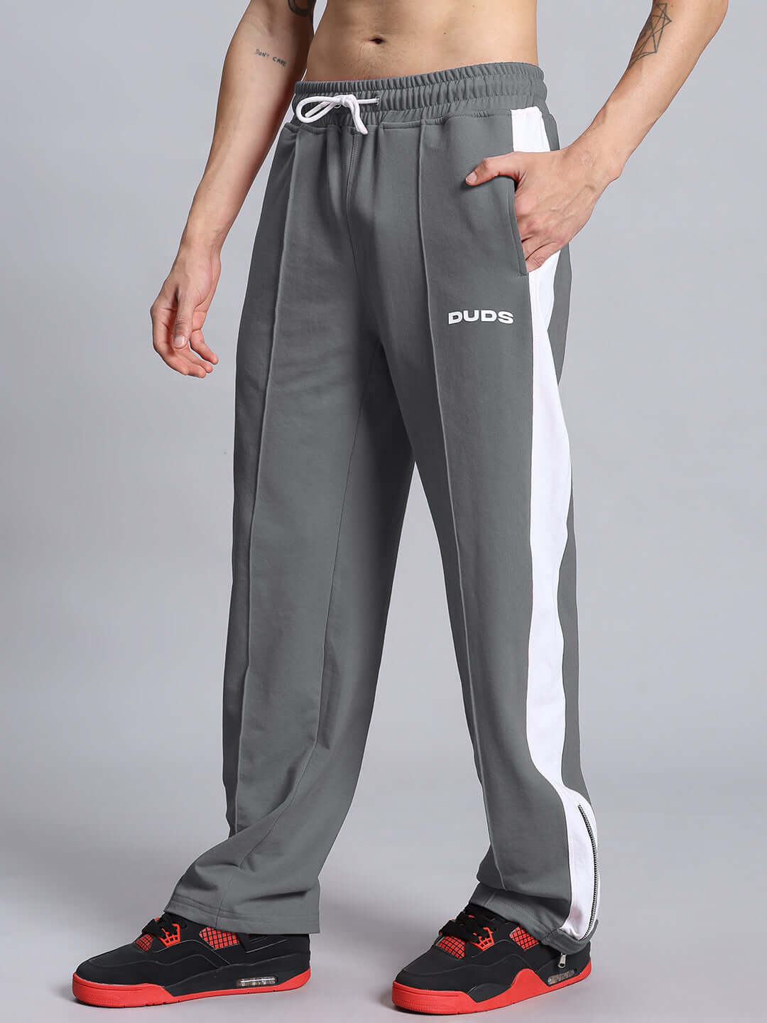 Grey white WONDER SLIT ZIPPER JOGGERS by DUDS, featuring custom fit option and comfortable design, worn with black and red sneakers.