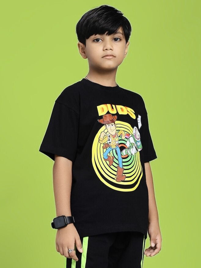 Child wearing WOODY BUZZ T-SHIRT FOR BOYS AND GIRLS BLACK with character graphic on green background