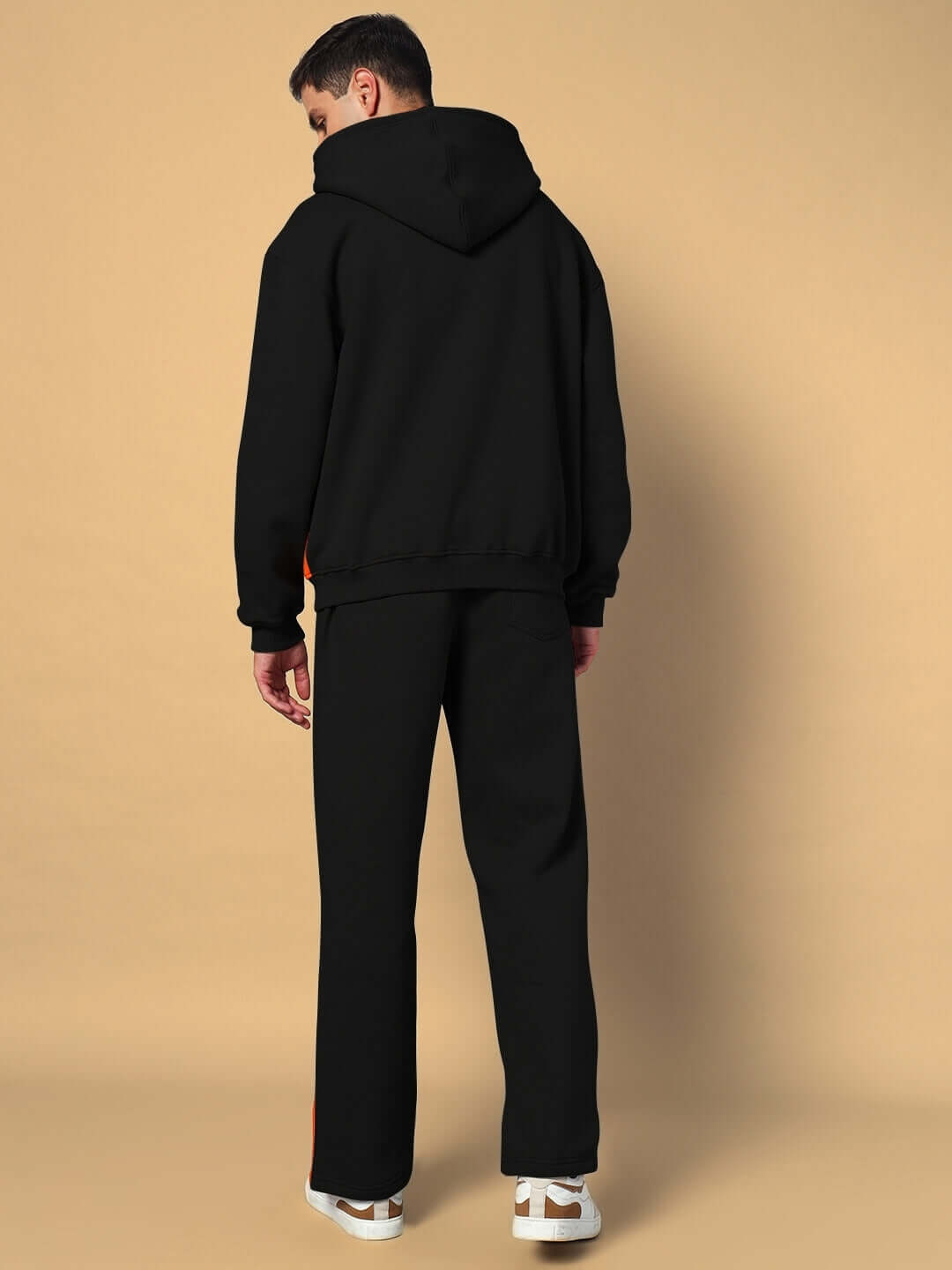 Model wearing WORLDWIDE FLEECE CO-ORD SET BLACK with hoodie and joggers, shown from the back for style and comfort display.