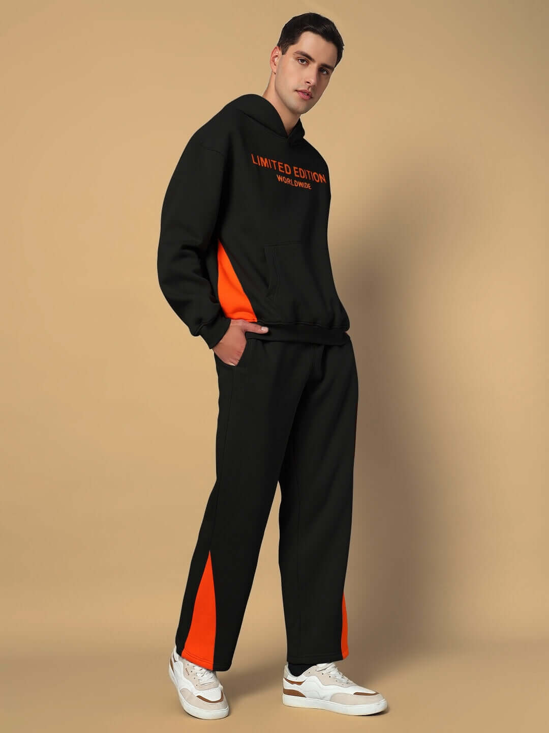 Man wearing WORLDWIDE FLEECE CO-ORD SET BLACK with orange accents, showcasing cozy fleece hoodie and joggers for ultimate comfort and style.
