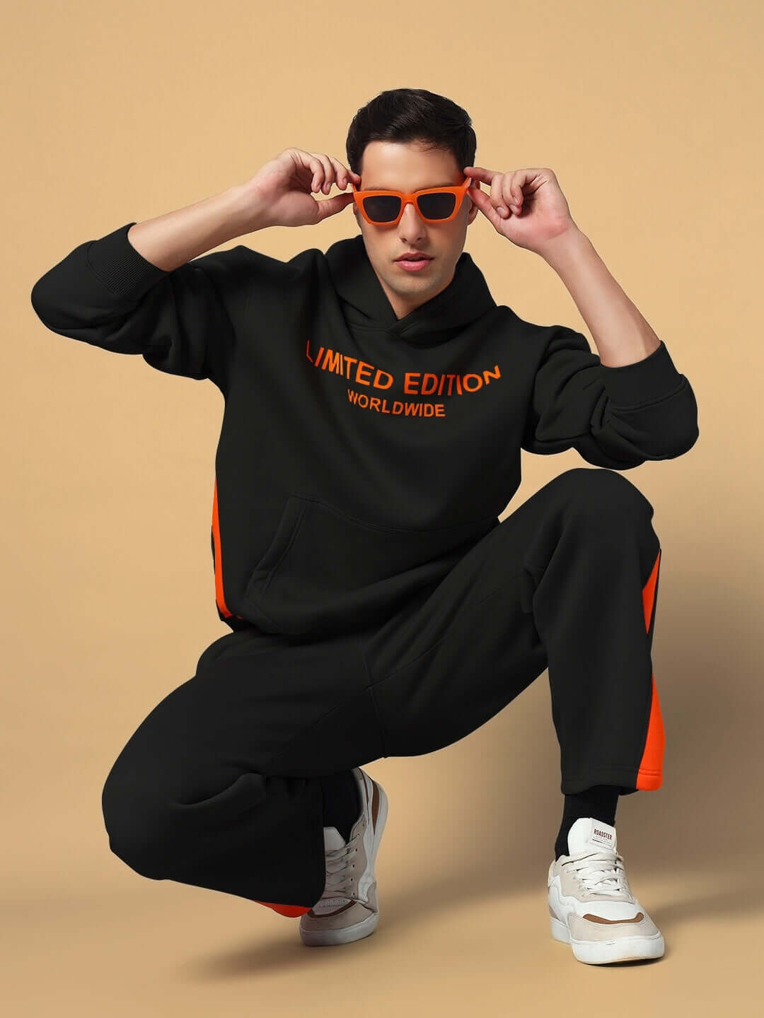 WORLDWIDE FLEECE CO-ORD SET BLACK featuring a model in a stylish black fleece hoodie and joggers with orange details, ideal for casual wear.