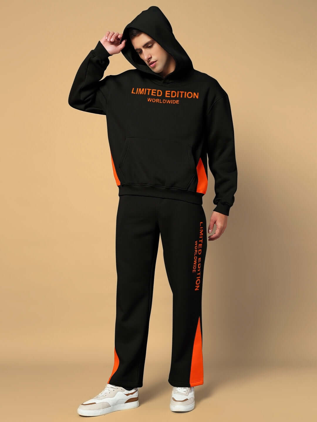Model wearing black Worldwide Fleece Joggers with orange accents and Limited Edition text, paired with a matching hoodie and white sneakers.