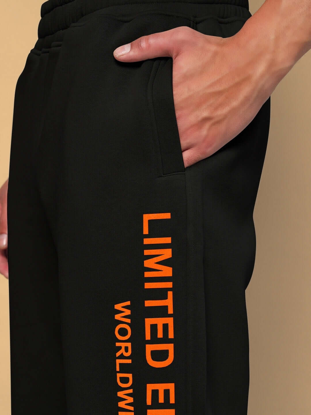 Close-up of black Worldwide Fleece Joggers with orange 'Limited Edition' text, showcasing side pocket and waistband detail.