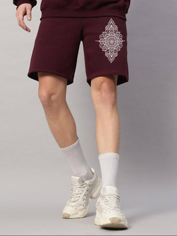 Person wearing WEARDUDS YANTRA FLEECE SHORTS WINE with an intricate design, showcasing stylish and comfortable casual wear.