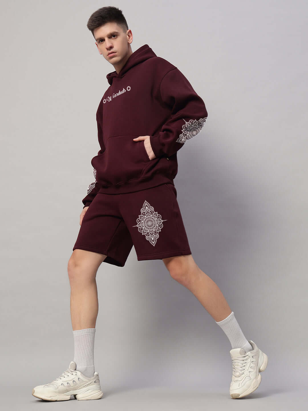 Model wearing WEARDUDS YANTRA FLEECE SHORTS WINE with floral design, showcasing sleek design and comfort.