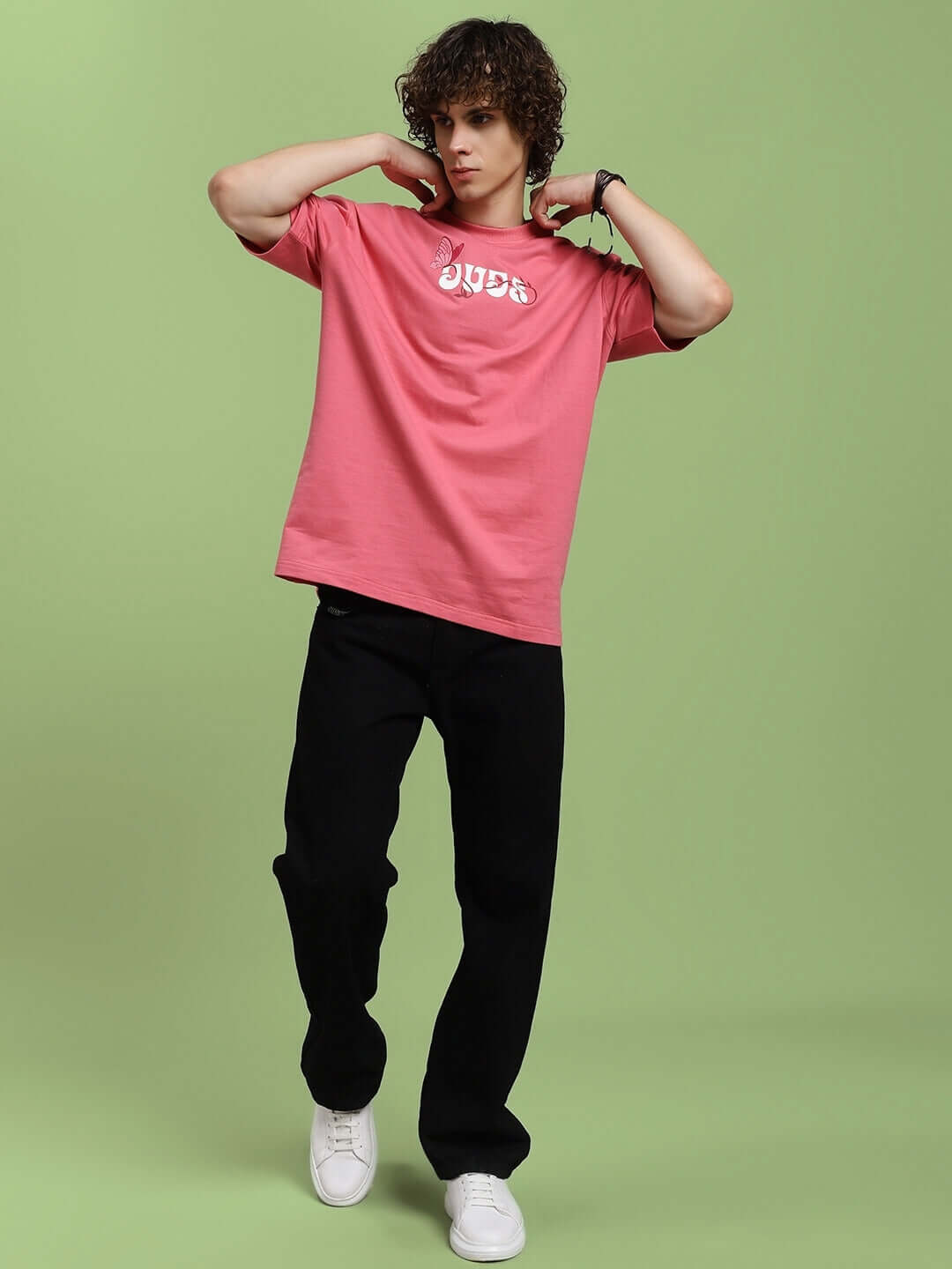 Model wearing YOUR FEELING PRINTED T-SHIRT PINK, showcasing casual style with bold print and relaxed fit, set against a green background.