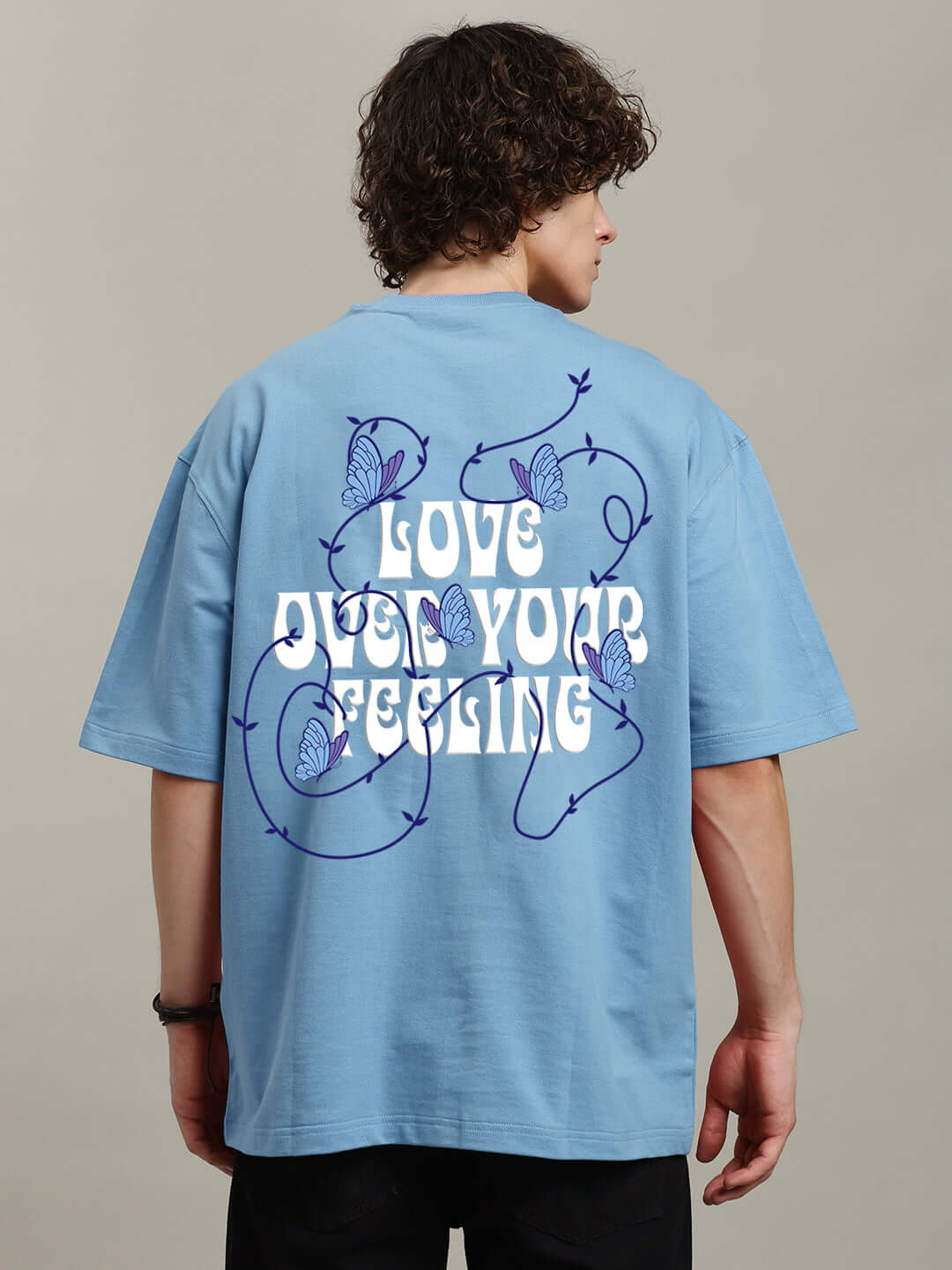 Man wearing a light blue printed t-shirt with 'Love Your Feeling' design, made of premium cotton French terry, 240 GSM, by Color By Colours.