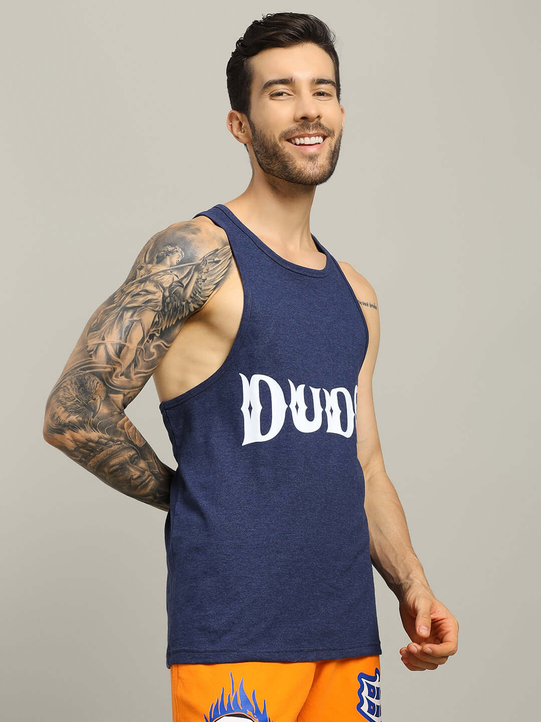 Man wearing ZEMPA FITNESS blue gym t-shirt by DUDS, showcasing athletic fit and tattooed arm, ideal for customized workout gear.