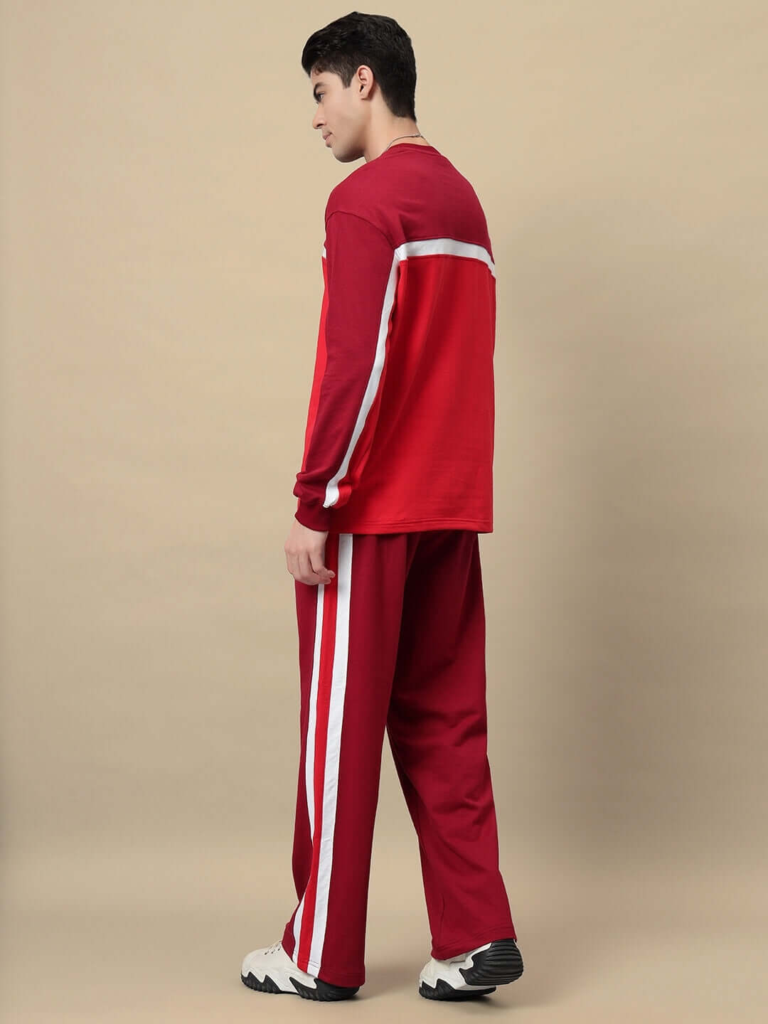 Male model wearing ZEST JOGGER in maroon, showcasing side profile with white stripe detail, suitable for custom fit orders by DUDS.