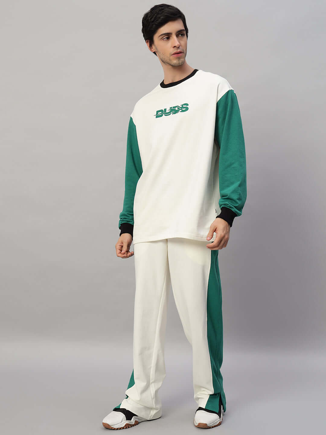 Man wearing ZINGY OVERSIZED CO-ORD SET OFF WHITE TEAL with unisex relaxed fit joggers, elastic waistband, and red & white panel.