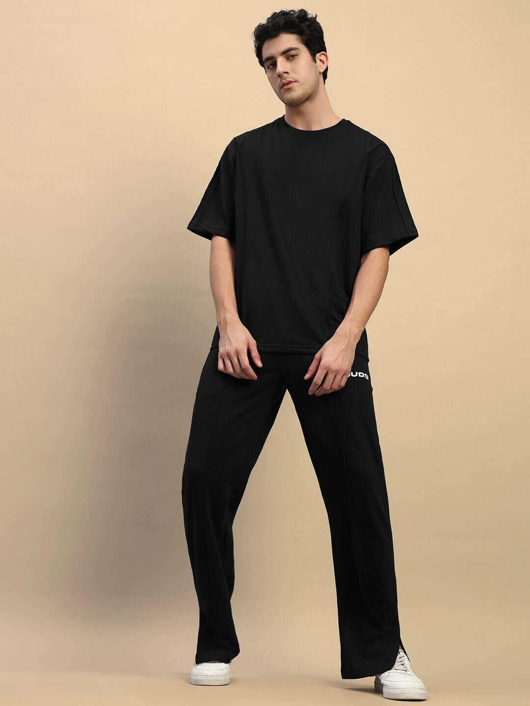 Model wearing Zion relaxed fit black co-ord set with elasticated waistband joggers and cotton t-shirt.