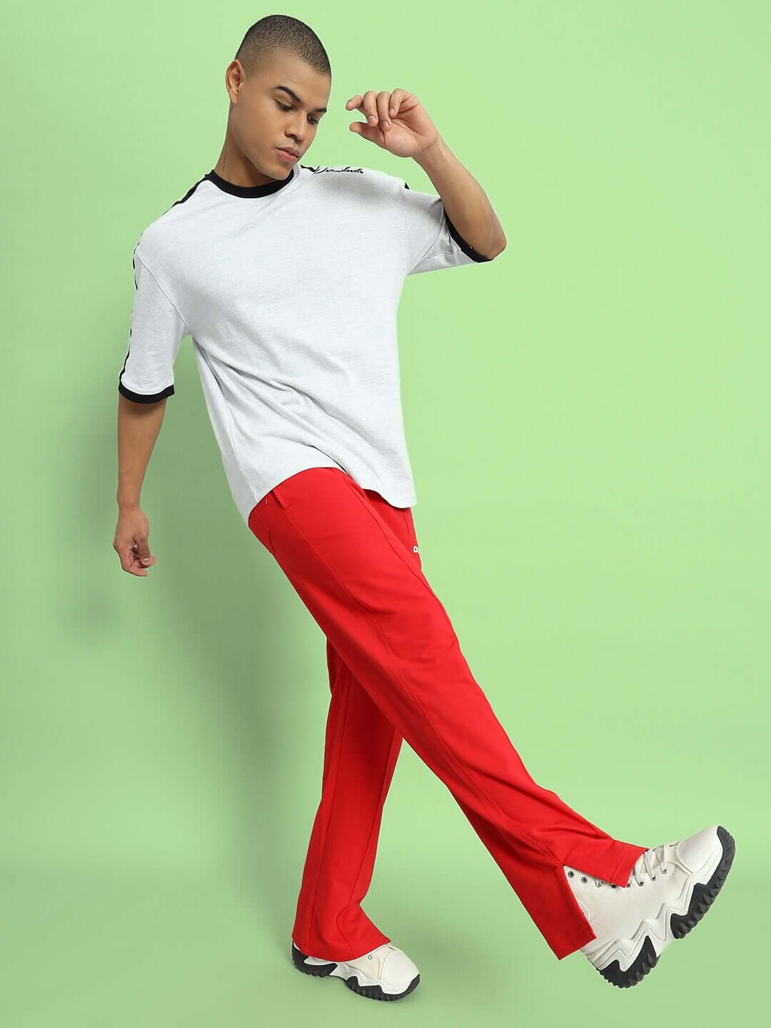 Model wearing ZION side slit joggers in red, stylish and comfortable, custom fit options available. Made by DUDS tailors, 7-10 day dispatch.