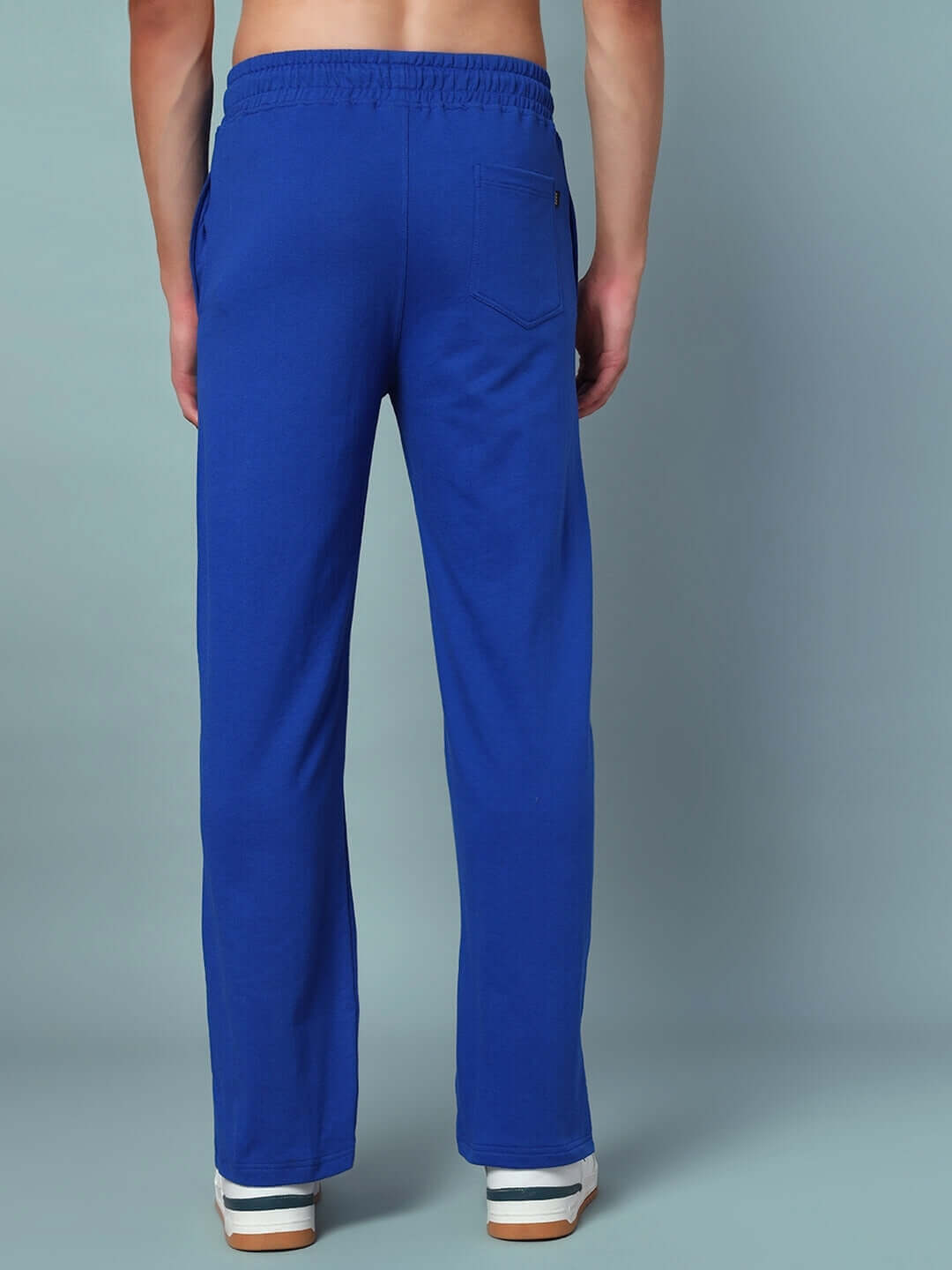 Back view of a model wearing royal blue Zion side slit joggers made by DUDS, showcasing elastic waistband and pockets.