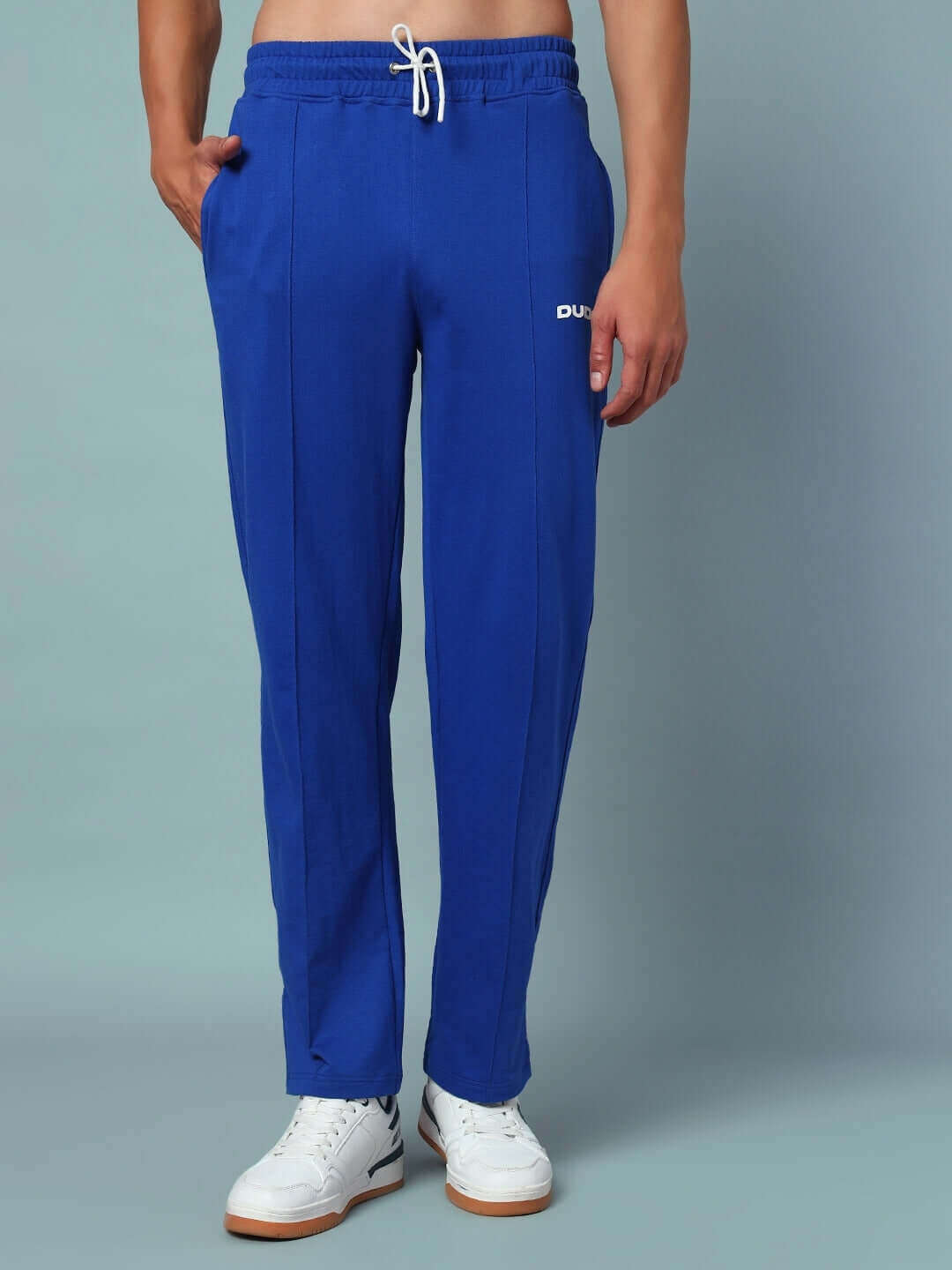 Model wearing ZION side slit joggers in royal blue color by DUDS, showcasing comfortable and stylish design with elastic waistband.