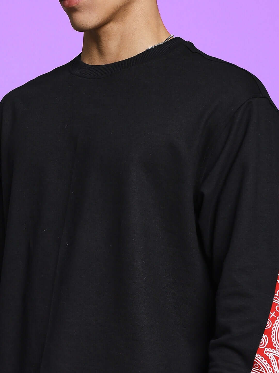 Black and red Zonex co-ord set with custom fit option, made by skilled tailors for DUDS, on a model against a vibrant purple background.