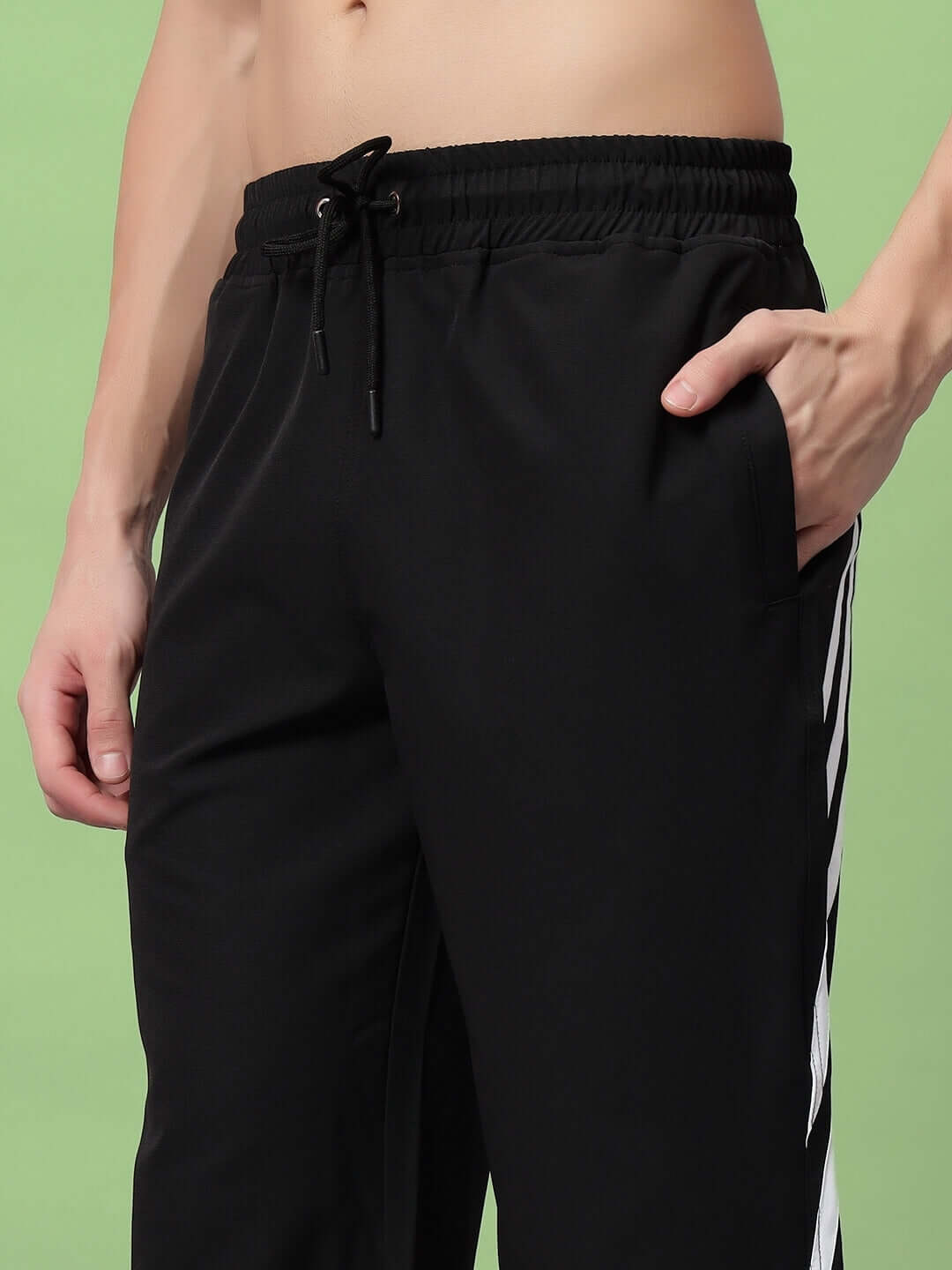 ZOOMER relaxed fit black cargo pants with spacious side pockets and adjustable waist, showcasing streetwear style on green background.