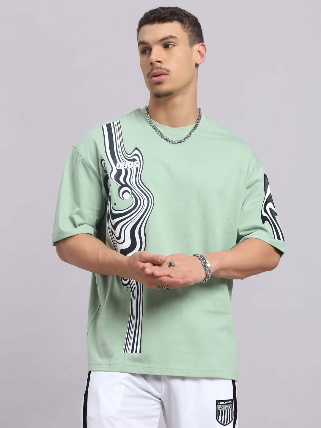 Model wearing Chimera oversized t-shirt in Nyanza Green with abstract pattern, made from premium cotton blend, perfect for casual wear.